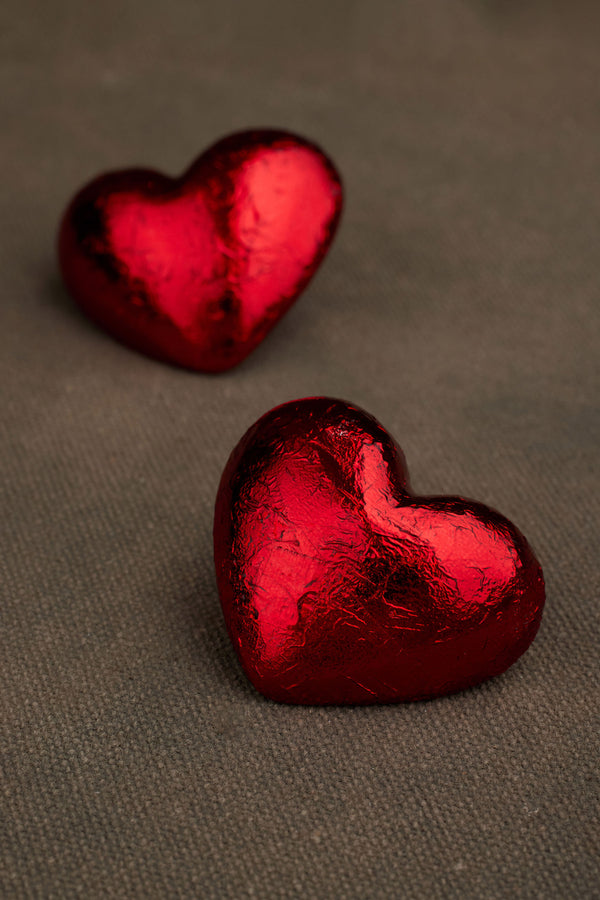 Close-up of AKER red foil heart-shape earrings